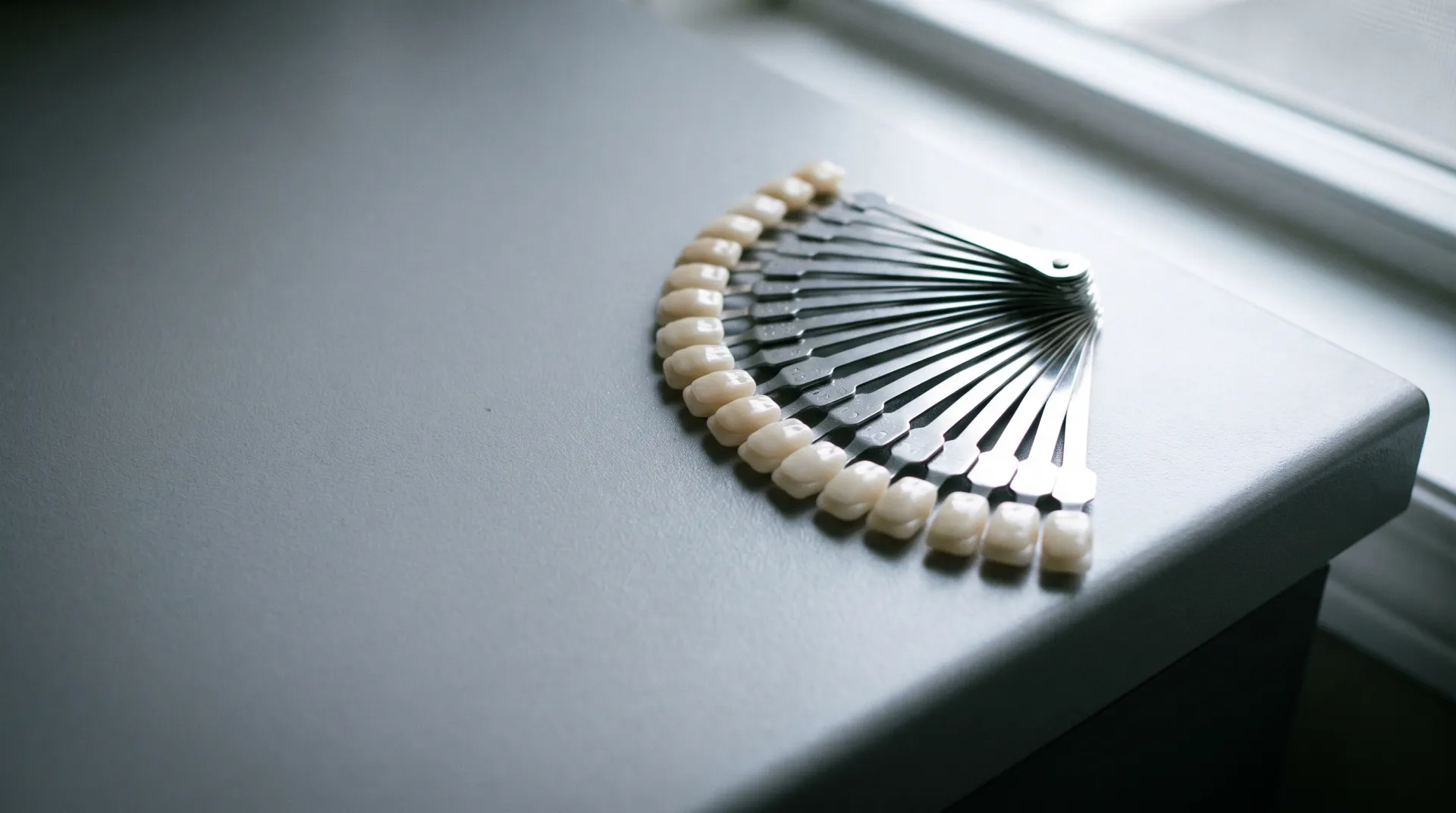 A fanned dental shade guide on a matte counter, illustrative